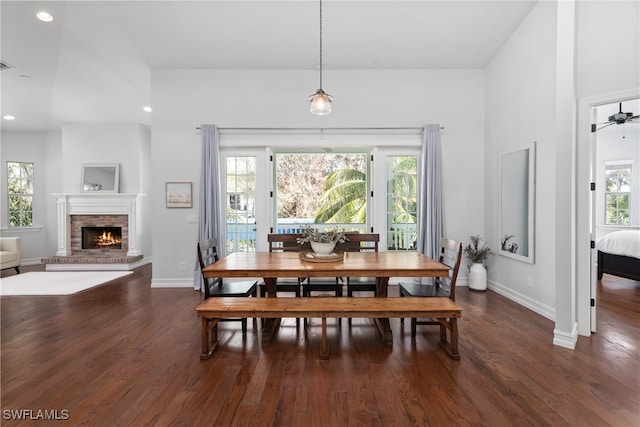 dining area featuring dark wood-type flooring, a fireplace, and ceiling fan