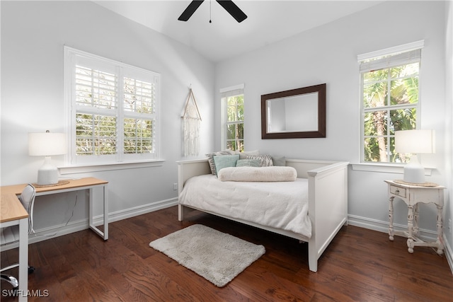 bedroom with multiple windows, dark wood-type flooring, vaulted ceiling, and ceiling fan