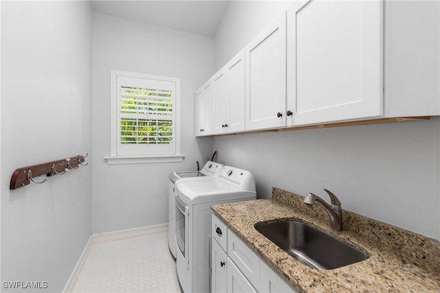 laundry area with tile patterned floors, cabinets, sink, and separate washer and dryer