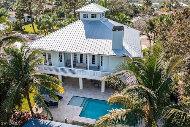 27232 J C Ln, Bonita Springs, FL 34135 - rear view of property with metal roof, a patio area, french doors, a balcony, and an outdoor pool