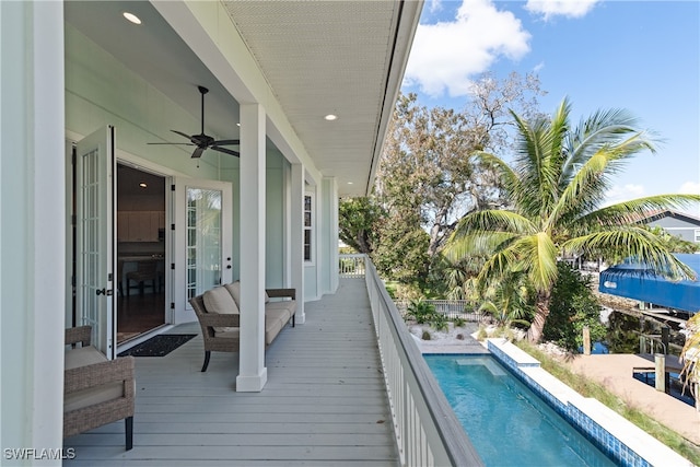 view of swimming pool featuring a deck and ceiling fan