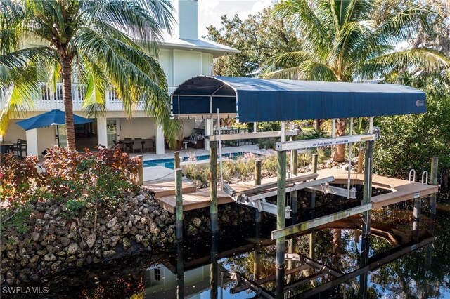 27232 J C Ln, Bonita Springs, FL 34135 - dock area with boat lift, an outdoor pool, and a patio