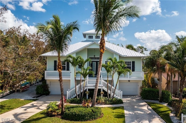 27232 J C Ln, Bonita Springs, FL 34135 - coastal home with a garage, driveway, stairs, and a porch