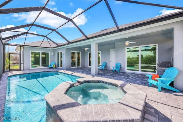 view of swimming pool with an in ground hot tub, glass enclosure, ceiling fan, and a patio area