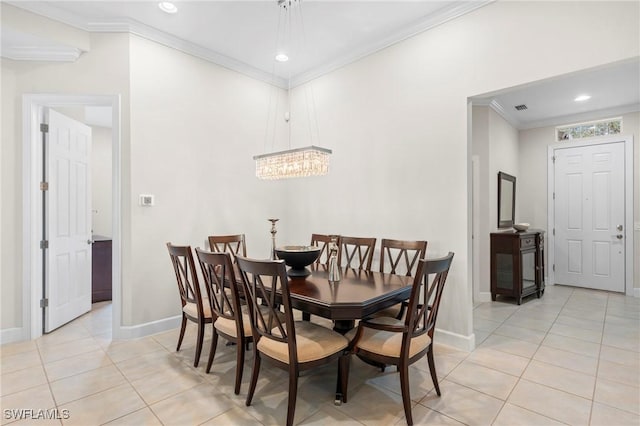 dining space featuring ornamental molding and light tile patterned floors