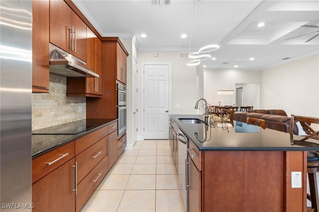 kitchen featuring an island with sink, appliances with stainless steel finishes, ornamental molding, and sink