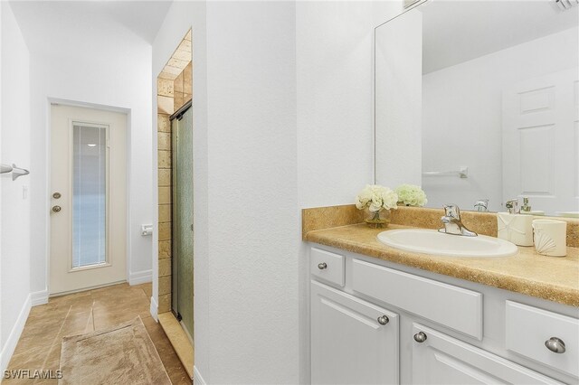 bathroom featuring vanity, a shower with shower door, and tile patterned flooring