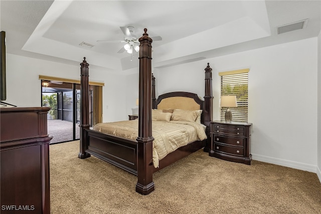 bedroom featuring ceiling fan, a raised ceiling, and access to exterior