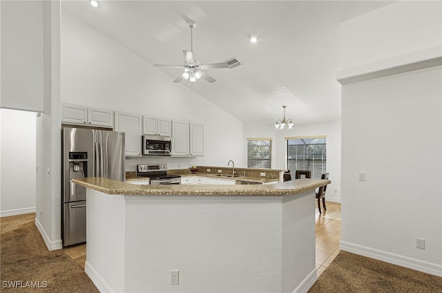 kitchen with white cabinets, appliances with stainless steel finishes, high vaulted ceiling, sink, and light colored carpet