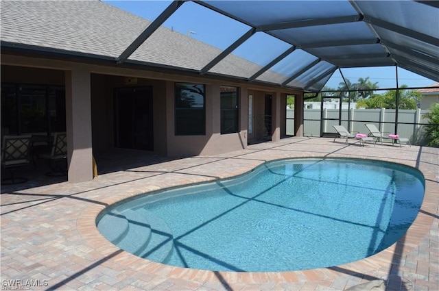 view of swimming pool with a patio area and a lanai