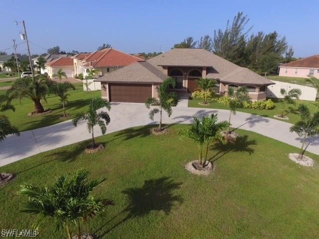 mediterranean / spanish-style home featuring a front yard and a garage