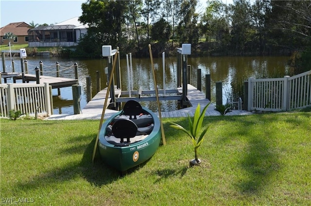 dock area featuring a lawn and a water view