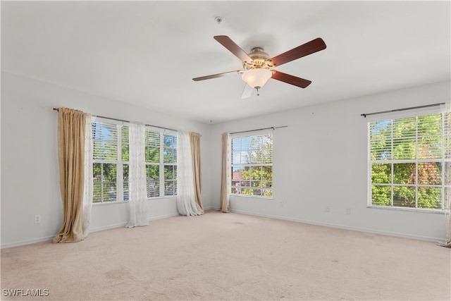 carpeted spare room featuring ceiling fan