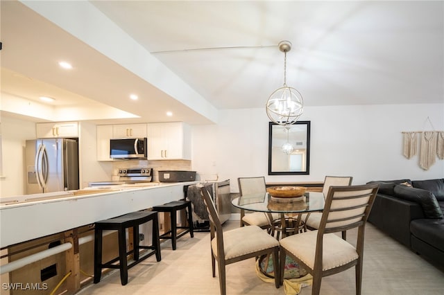 dining area featuring a tray ceiling, an inviting chandelier, and recessed lighting