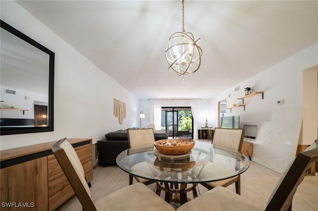 dining space featuring visible vents and a notable chandelier