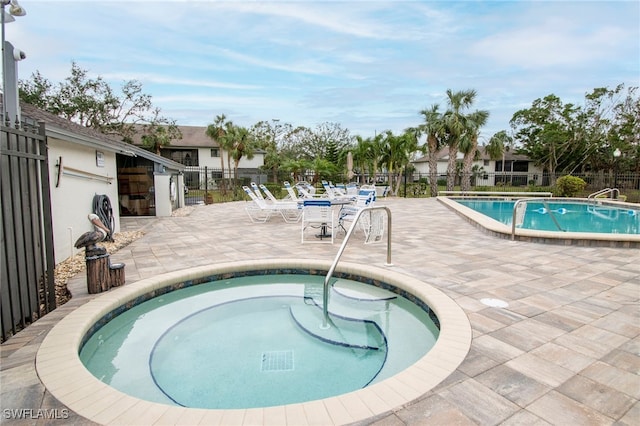 pool featuring a patio area, fence, and a community hot tub