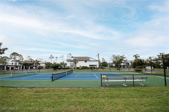 view of sport court featuring a residential view, a lawn, and fence