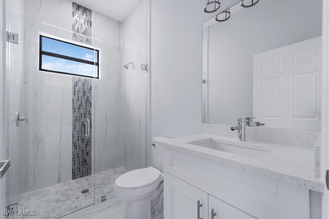 bathroom featuring vanity, a shower with shower door, and toilet