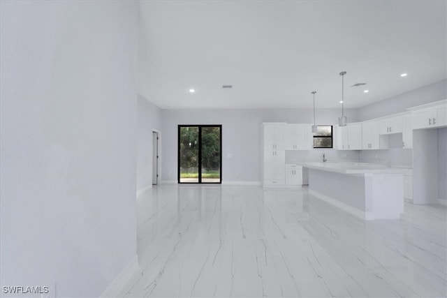 kitchen with white cabinetry, pendant lighting, and a kitchen island