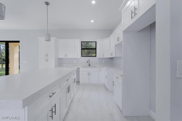 kitchen with white cabinets, sink, pendant lighting, and a kitchen island