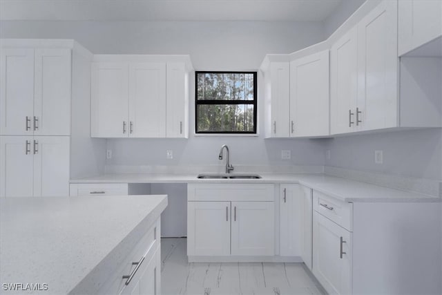 kitchen featuring white cabinetry and sink