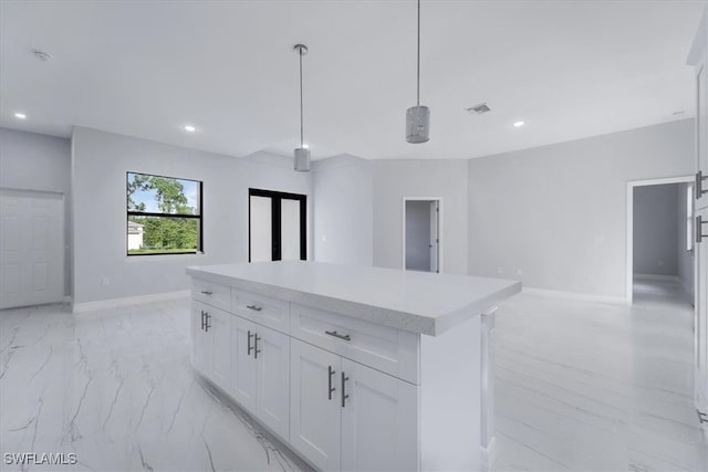 kitchen featuring a center island, white cabinets, and decorative light fixtures