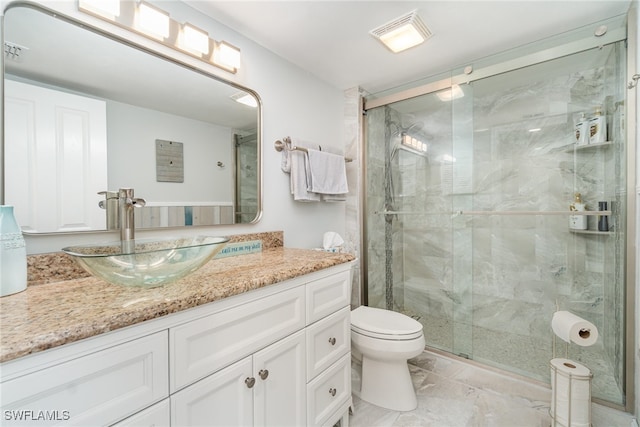 bathroom with walk in shower, vanity, and toilet