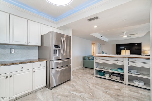 kitchen with white cabinets, stone counters, stainless steel fridge with ice dispenser, ceiling fan, and backsplash