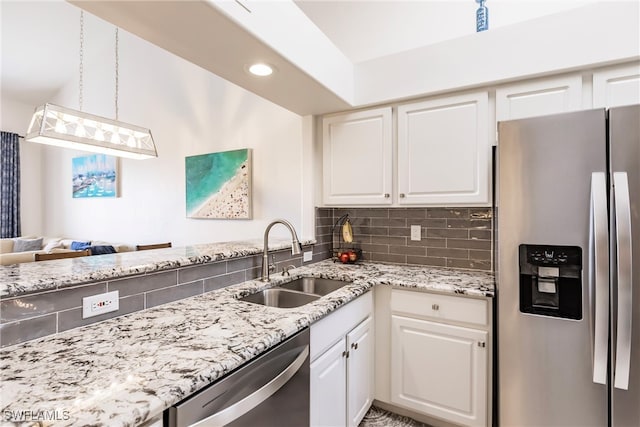 kitchen with white cabinets, tasteful backsplash, stainless steel appliances, and sink