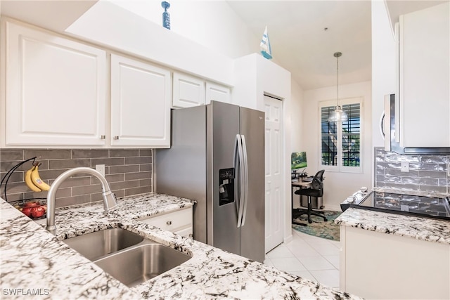 kitchen featuring decorative backsplash, white cabinets, stainless steel appliances, pendant lighting, and sink