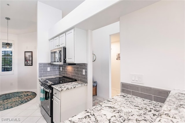 kitchen with black range with electric cooktop, light stone countertops, backsplash, hanging light fixtures, and white cabinets