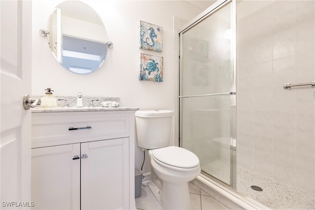 bathroom with vanity, tile patterned flooring, toilet, and an enclosed shower