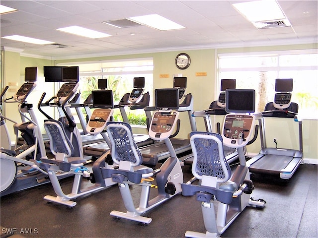 gym with a drop ceiling and crown molding