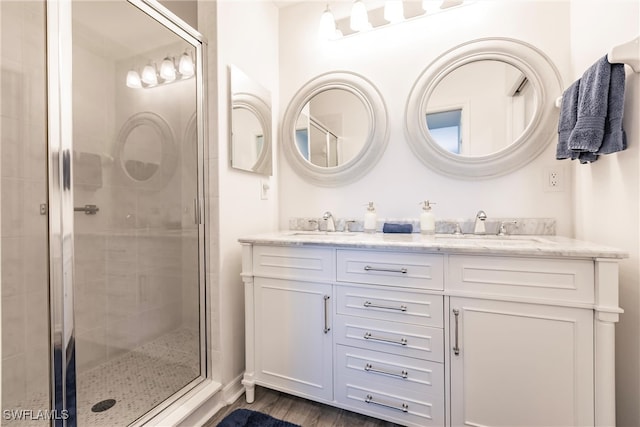 bathroom with a shower with door, hardwood / wood-style floors, and vanity