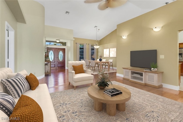 living room featuring ceiling fan, wood-type flooring, and high vaulted ceiling