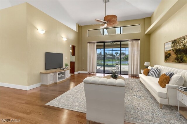 4632 Shearwater Ln, Naples, FL 34119 - living room with ceiling fan, a high ceiling, wood finished floors, and baseboards