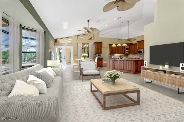 tiled living room with ceiling fan with notable chandelier and high vaulted ceiling