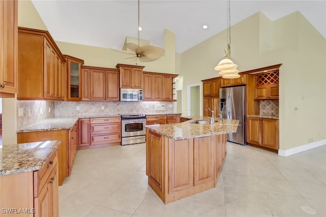 kitchen with stainless steel appliances, decorative light fixtures, high vaulted ceiling, decorative backsplash, and a kitchen island with sink