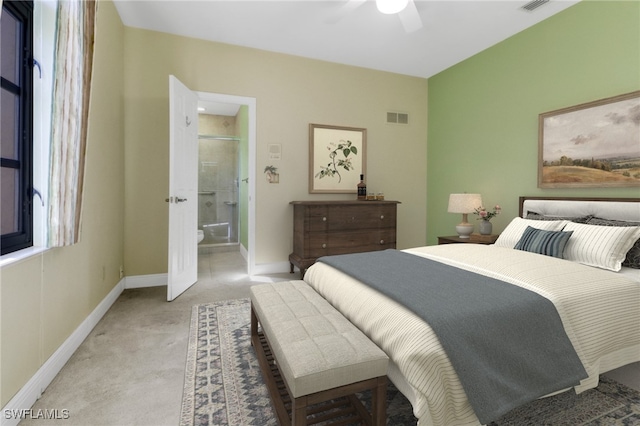 bedroom featuring light colored carpet, ceiling fan, and ensuite bath