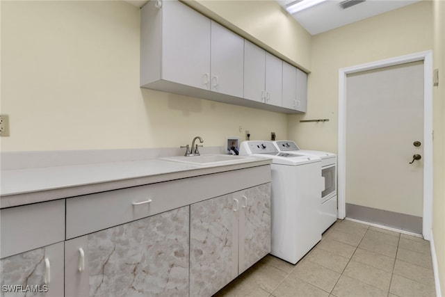 clothes washing area featuring cabinets, washing machine and dryer, sink, and light tile patterned floors