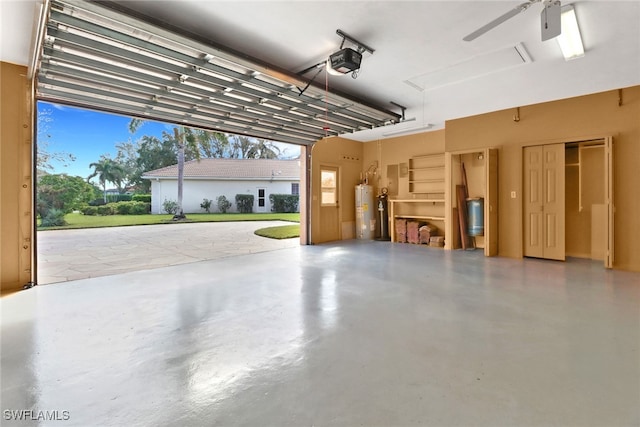 garage with ceiling fan, gas water heater, and a garage door opener