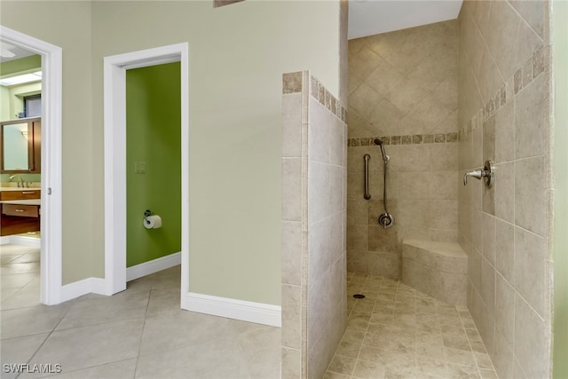 bathroom featuring vanity, tile patterned floors, and a tile shower