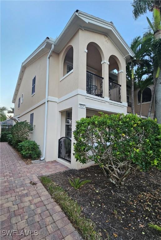 view of property exterior with stucco siding and a balcony