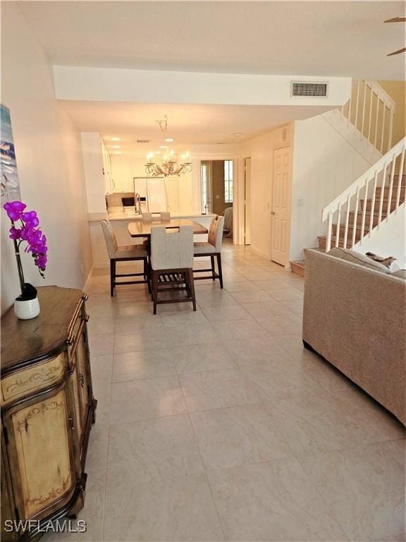 dining area featuring stairway, visible vents, and a notable chandelier
