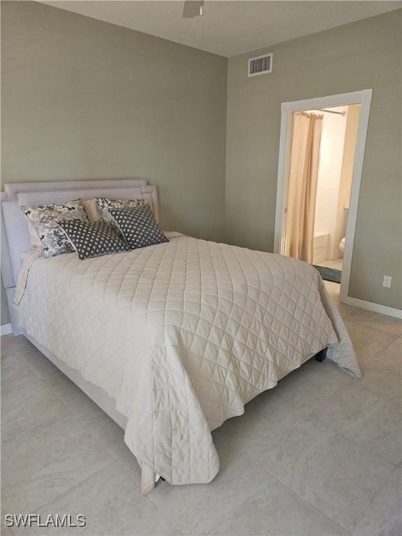 bedroom with ceiling fan, visible vents, tile patterned floors, baseboards, and ensuite bath