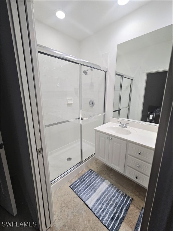 bathroom with vanity and a shower with shower door