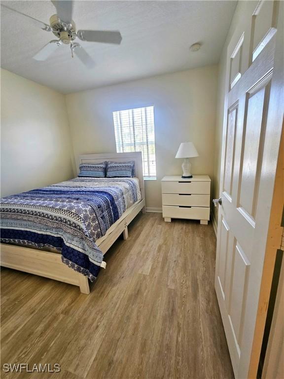 bedroom featuring baseboards, ceiling fan, and wood finished floors