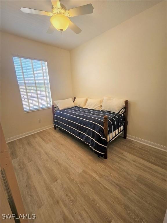 bedroom with baseboards, ceiling fan, and wood finished floors