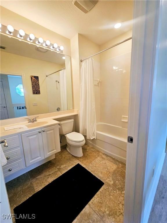 full bathroom with toilet, shower / bath combination with curtain, and vanity