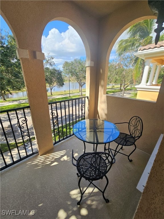 view of patio featuring a water view and a balcony